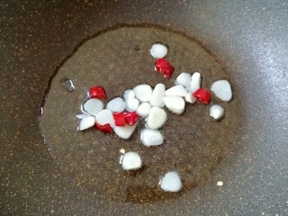 4、清炒茼蒿杆,锅内倒适量的食用油烧热,下入蒜片和干红辣椒炒香。