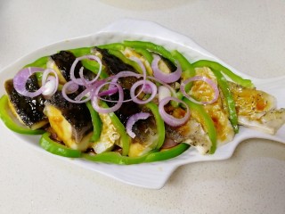 16、清蒸草鱼,鱼肉之间摆上青椒丝，上面放上剩下的小圆葱圈。