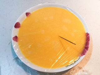 13、南瓜鸡蛋羹,盖上耐高温保鲜膜，用牙签扎出小洞用于排气