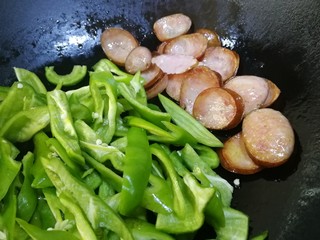 9、青椒炒香肠,把香肠推到一边,放入螺丝椒。