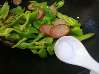 13、青椒炒香肠,红肠有咸味,放半小勺盐就可以,炒匀。
