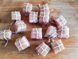 5、东坡肉,用棉线将每块肉都捆扎起来。扎棉绳是为了保持在长时间炖煮过程中肉不会散掉。
