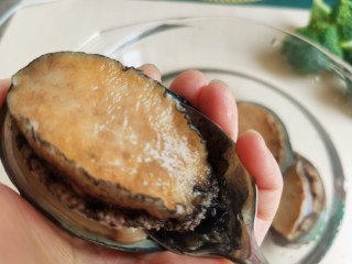 2、鲍鱼捞饭,给鲍鱼去壳，用吃饭的不锈钢饭勺比较方便，薄一点的饭勺更好用。左手拿稳鲍鱼，右手将饭勺从鲍鱼一头的肉和贝壳间铲进去，铲断鲍鱼背柱，这样就很容易把鲍鱼肉和壳分离开来。