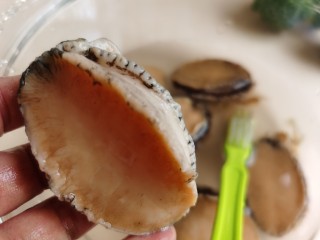 3、鲍鱼捞饭,去除鲍鱼内脏，用一个小刷子把鲍鱼表面的的黑色物刷干净。再从鲍鱼嘴巴处划一刀，取出食胃管。