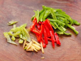 2、安康鱼清炖菜花,先把青红椒去籽后切条，葱姜切丝。