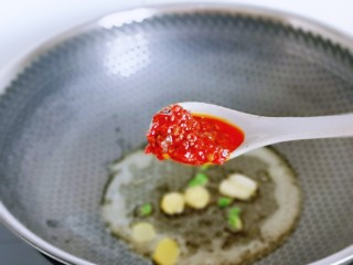 6、香辣鱿鱼须,起油锅,加入葱姜蒜炒香,红辣椒段,再加入1勺辣肉酱,可以根据个人喜好增加。