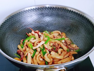 11、香辣鱿鱼须,加入青椒丝,快速翻炒均匀,关火出锅。
