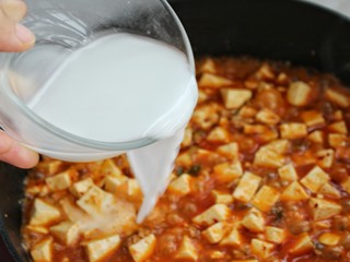 13、家常麻辣豆腐,分三次调入水淀粉（调入水淀粉后同样晃动锅子，使豆腐能均匀的勾上芡汁）