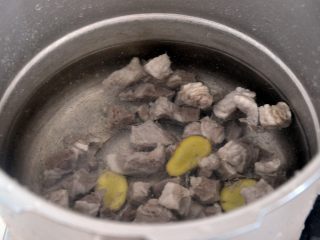 2、罗宋汤, 将焯过水的牛腩,放入高压锅中,倒入冷水,放上几片姜,盖上盖子压20分钟,这样会相对比较省时。