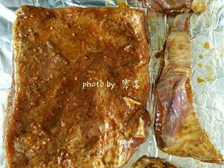 5、黑椒烤羊排,烤盘铺一张锡纸，放上腌制过的羊排，再在羊排上覆盖一张锡纸；