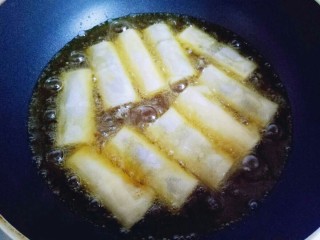 10、炸春卷,炸锅中放入食用油，油温8成时用筷子夹入包好的春卷。