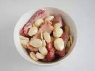 2、〔家制蒜香排骨〕,排骨碗中加入鸡粉、白砂糖、盐和生抽用保鲜袋密封腌制半天