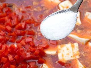 11、麻婆豆腐,再加入红辣椒末,适量的加些盐和胡椒粉,轻轻搅动均匀,转小火。