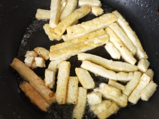 3、鱼香豆腐条,锅内倒入色拉油 ，烧热后下豆腐条，煎至金黄色 ，捞出控油。