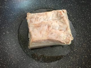 11、梅菜扣肉,锅里放入适量油，五花肉放入锅中，肉皮朝下，盖上锅盖，小火炸至肉皮焦黄