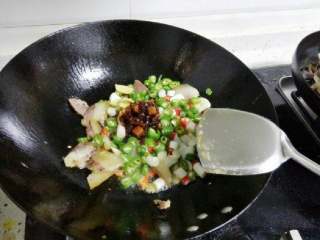 5、干锅土豆片,锅里放油,烧热后放入腊肉炒香,加入切好的青红辣椒,葱姜蒜和一勺豆瓣酱或老干妈。