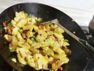 7、干锅土豆片,倒入炸好的土豆片。均匀翻炒后加入小半勺醋、适量盐和鸡精出锅。