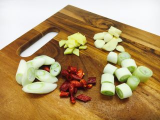 6、宫保鸡丁,大葱一部分切象眼片,一部分切段,干辣椒切段,姜切片,蒜切片。