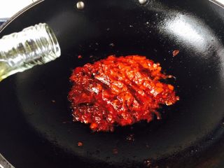 19、宫保鸡丁,当油温2成热时放入郫县豆瓣酱,番茄酱,剁椒酱,炒匀,倒入1勺料酒。