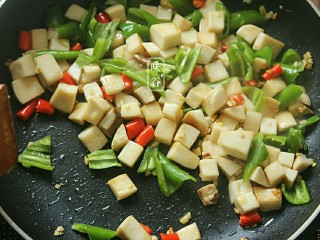 9、宫保杏鲍菇,倒入青椒翻炒至青椒断生。