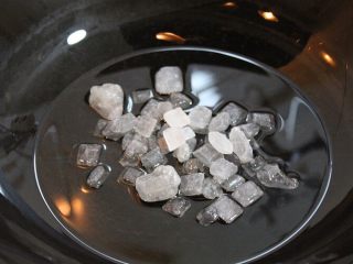 3、红烧排骨,锅烧热加适量油，加入冰糖，小火翻炒。