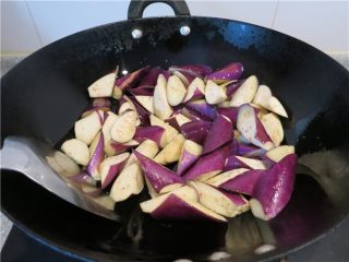 6、颜值超高的红烧蚝油紫茄子,油热后将茄子放入翻炒