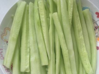 2、紫菜包饭,将洗净切段的黄瓜切成长细条，装盘待用