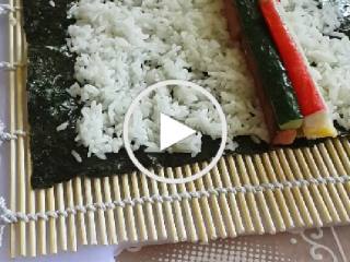 4、紫菜卷寿司,4寿司席子放上紫菜片，把适量的饭平铺在紫菜片上，放上火腿条、鸡蛋条、青瓜条、蟹柳