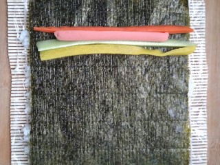 10、不拘一格吃寿司,将事先准备的食材放好，记住，放食材的位置在两端，而且要就两厘米左右的空隙。