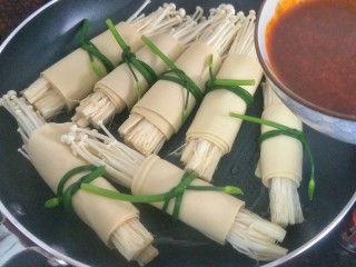 9、金针菇豆皮卷,把酱料倒入后开中火煮大约一分钟
