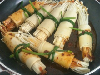 10、金针菇豆皮卷,把金针菇豆皮卷翻面再煮大概一分钟后熄火