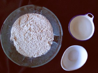 2、荞麦时鲜海螺面,面粉中加入少许盐，稍拌，逐次加入水，用筷子将面粉搅拌成絮状。