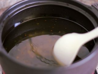 3、砂锅丸子粉丝汤,倒入三分之一包火锅底料、半勺盐，盖上盖子，启动程序烧开水。