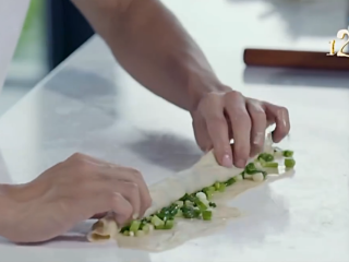 6、十二道锋味之葱油饼,将包有葱片的面皮卷成长条