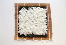 5、紫菜包饭,将拌好盐和香油的米饭平铺在上面。