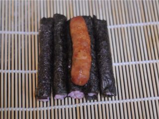 13、花朵寿司——小朋友最爱哦,将五条饭团放在寿司帘上，香肠摆放在饭团上方