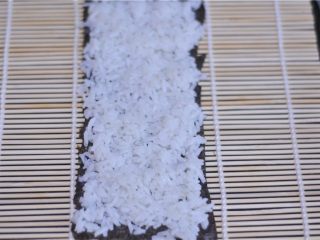 18、花朵寿司——小朋友最爱哦,另外半片海苔上均匀地摆放上白色米饭，