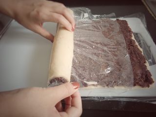 9、赖爸芸豆卷,抻住保鲜膜两侧，借助保鲜膜卷起