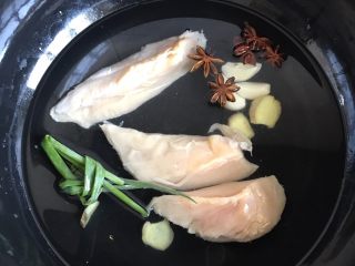 3、凉拌香辣鸡丝,放进锅里,倒入清水没过鸡胸肉(为了更易煮熟,顺着纹路一分三啦)加葱姜蒜八角