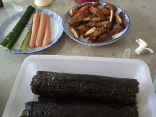 3、鸡肉寿司,然后用卷帘把海苔卷起来