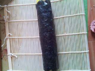 5、自制寿司,用竹帘把海苔卷起来