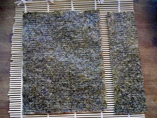 5、樱花寿司,将大张海苔切掉1/4。