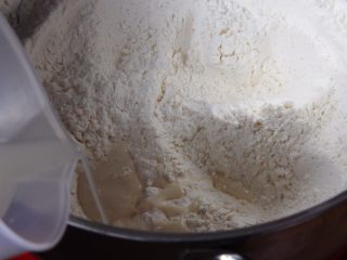 2、起酥面包,温水37度左右,发酵粉倒入温水中孵化,再倒入厨师机内搅拌。