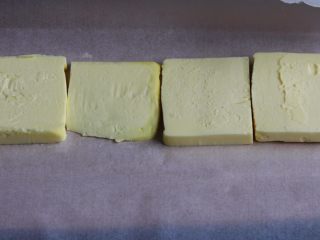 12、起酥面包,面团发酵中,拿出融软的黄油,切成片。