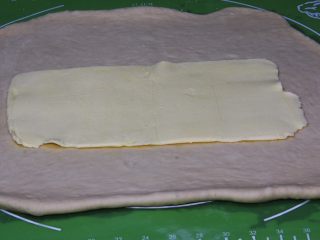 17、起酥面包,把面团擀成长方形,黄油片放入。