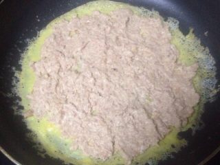 5、自制蛋卷,煎好一个蛋皮，等它稍微冷却就铺肉馅上去，用勺子尽量压紧压平实。然后把蛋皮边缘稍微往里面折一下，方便卷好后成型，肉不会跑出来。