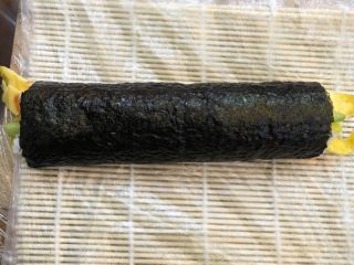 5、轻食 自制 DIY家庭寿司,卷起竹帘,将海苔边卷起边握紧,以致卷成海苔卷