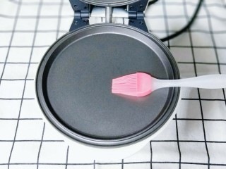 8、网红蕾丝蛋卷#华夫饼机器版#,刷上少许食用油，将华夫饼机器接上电源，预热2分钟。