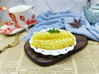 11、网红蕾丝蛋卷#华夫饼机器版#,做好的蛋卷用铲子轻轻铲动，之后取出再卷起来即可。(可以利用一双筷子，从一头往里卷就完成啦！依次将面糊做完。