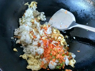 8、五彩炒饭,将胡萝卜丁倒入锅中，放适量的盐翻炒。